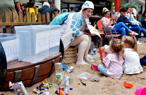 The beach litter picking activity with woman dressed as turtle reading children a story